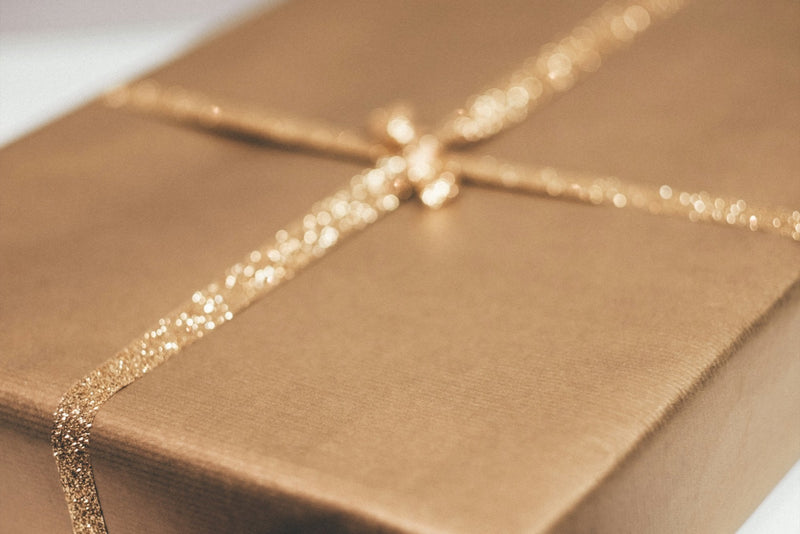 Ruban doré noué sur un coffret clair
